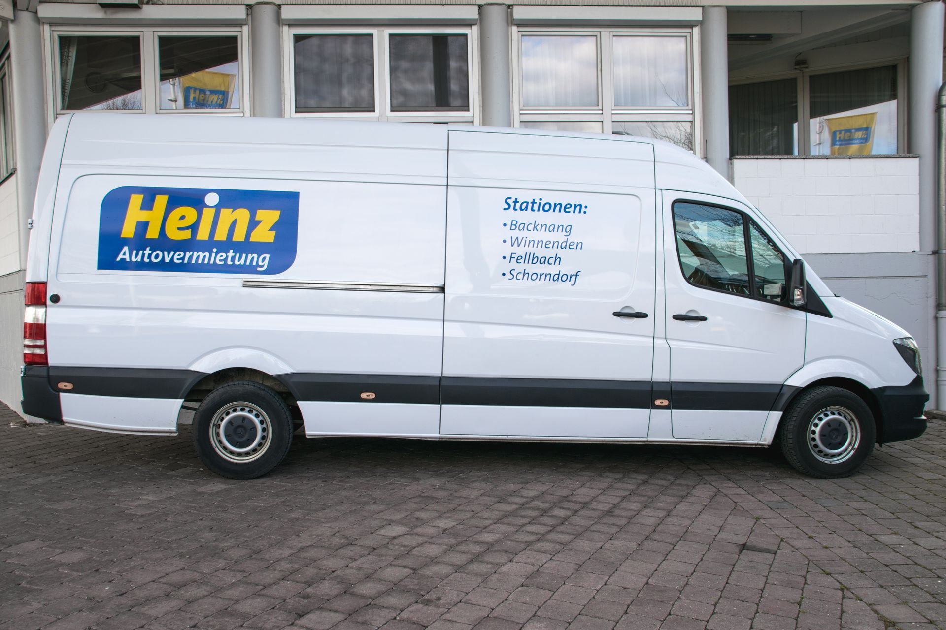 Fahrzeugmodelle Schwarze Kompaktlimousine, geparkt in einer Garage vor einer weißen Wand, Seitenansicht