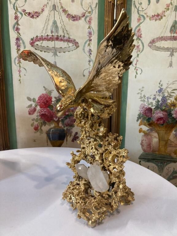 Bronze doré représentant un aigle aux ailes déployées sur un massif de rocaille et de quartz de roche blanche.
TAMPON DU FONDEUR : BOETZ PARIS
Objet d'art décoratif pouvant également de centre de table.
Claude Victor BOETZ  (né en 1937), artiste français, est devenu une figure importante du monde de l'art du XXe siècle. Il développe tôt un intérêt pour l’art, la géologie et les sciences – qui auront une place prépondérante dans son travail.

