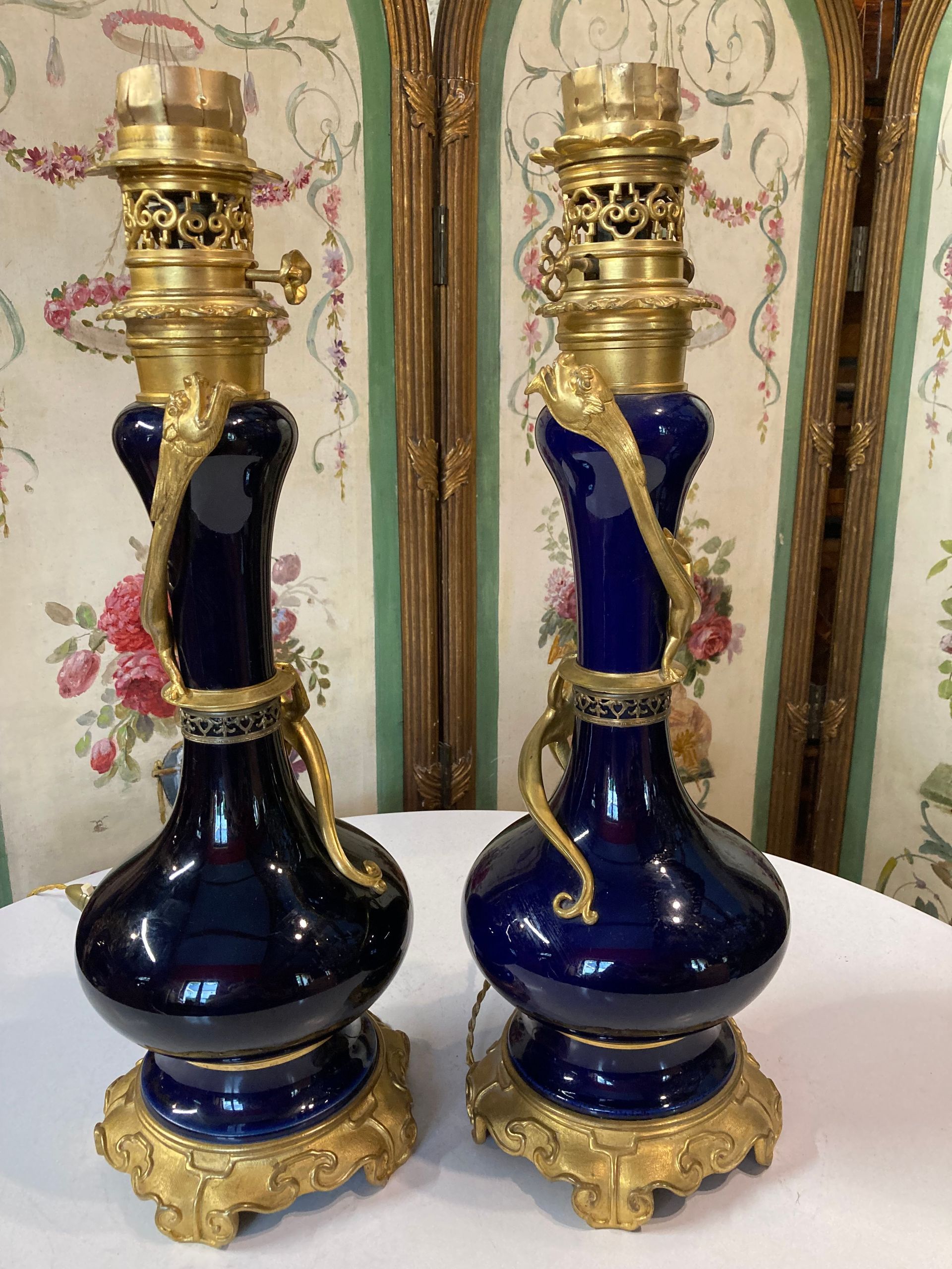 Jolie paire de lampes 19ème,
En porcelaine de forme ovoïde à long col de couleur bleue et bronze doré
Col entouré par un lézard, 
Base à décor de feuillage stylisé, 
Lampes originales et décoratives montées à l'électricité.