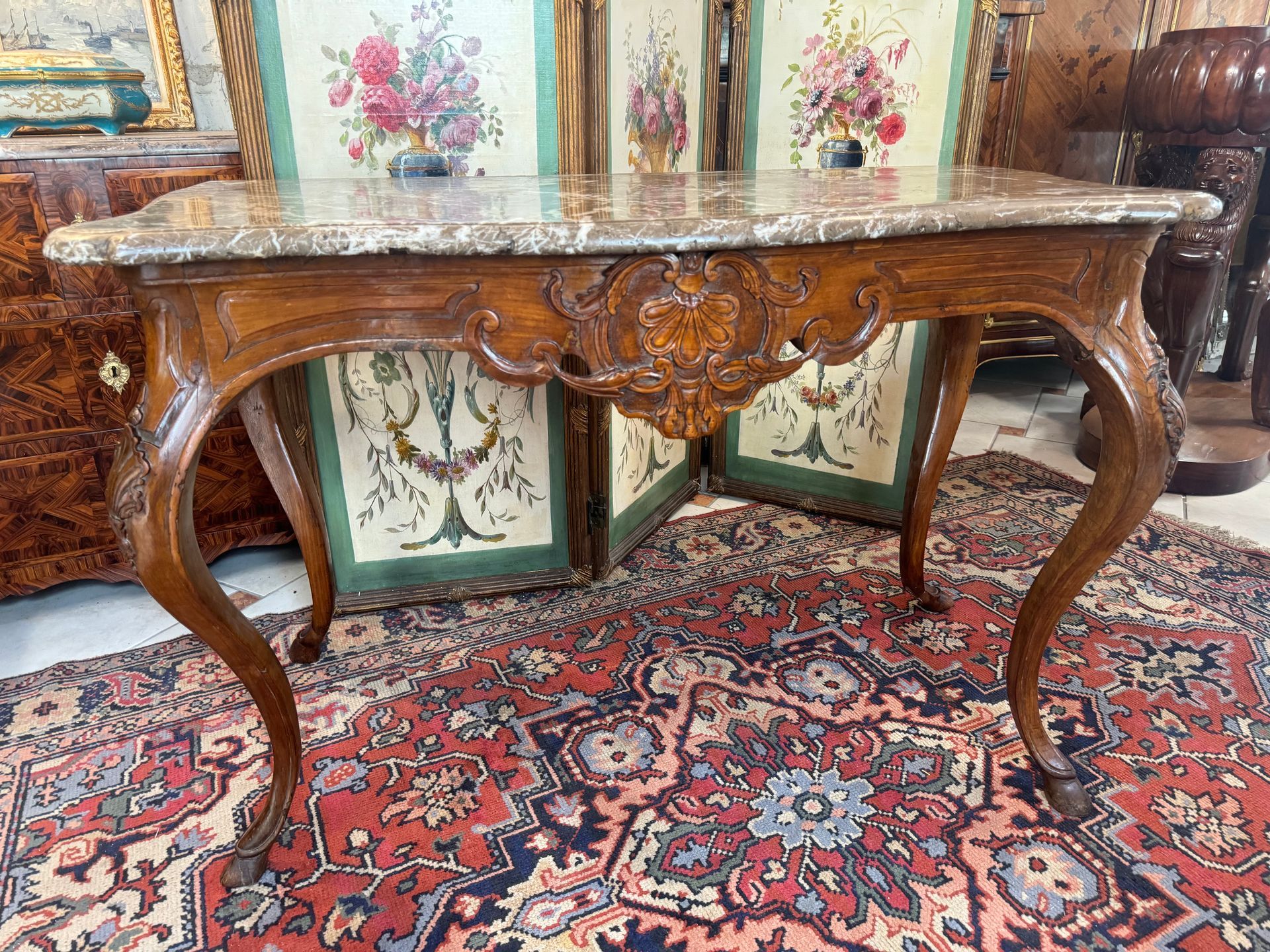 Table à gibier Louis XV – 18ème en noyer,
Elle présente une jolie traverse sculptée d'une coquille en façade, un décor de feuille d’acanthe sur le montant des pieds et sur les côtés.
Elle repose sur quatre pieds galbés terminés par des enroulements appelés « pied biche »
Le tout coiffé d’un marbre brèche bec de corbin,
Travail régional du XVIIIème.