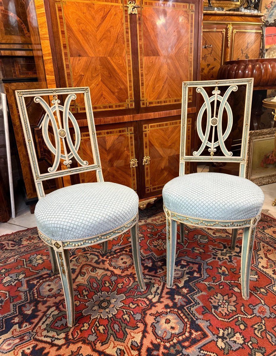 Paire de chaises de style Directoire Louis XVI en bois laqué réchampi bleu,
Pied gaine ,
Guirlande de perles sur le bandeau et le haut,
Dossier ajouré entrelacé
Assise en bon état.