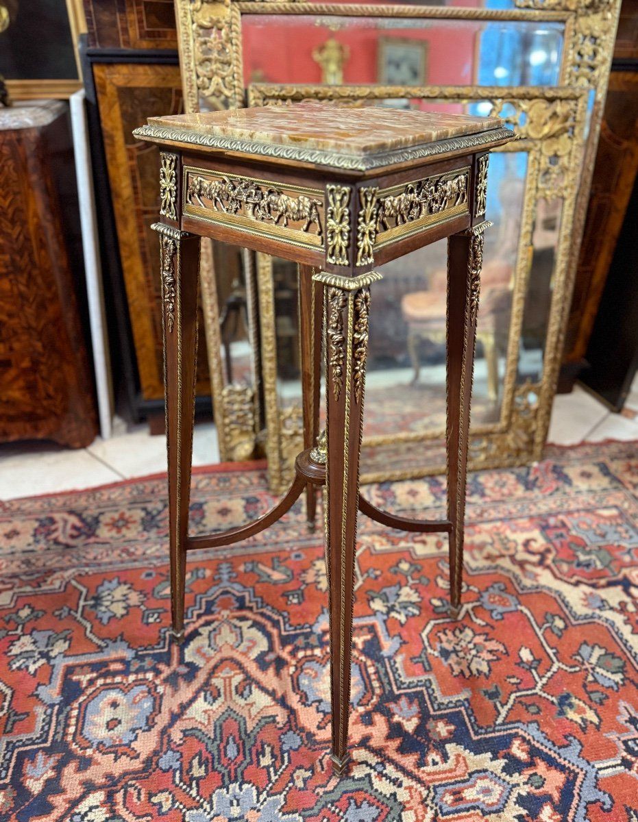 Sellette de style Louis XVI en acajou,
Riche décor de bronze ciselé doré toute face représentent des bouquetins mangeant du raisin ,
Filet de bronze tosade sur les pieds, guirlande de fleurs, galerie en bronze,
Entretoise au milieu se terminant avec un bronze représentant une flamme,
Pied  fuselé avec sabot,  tablette sur le côté,
le tout coiffé d'un onyx orangé sur le dessus
Travail dans le goût de François LINKE.