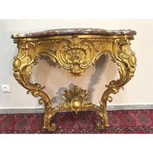 Console d'applique en bois doré richement sculptée de forme mouvementée,
 Elle repose sur deux pieds réunis par une entretoise.
Style Louis XV.
Dessus de marbre epais veiné rouge.
Epoque Napoléon III