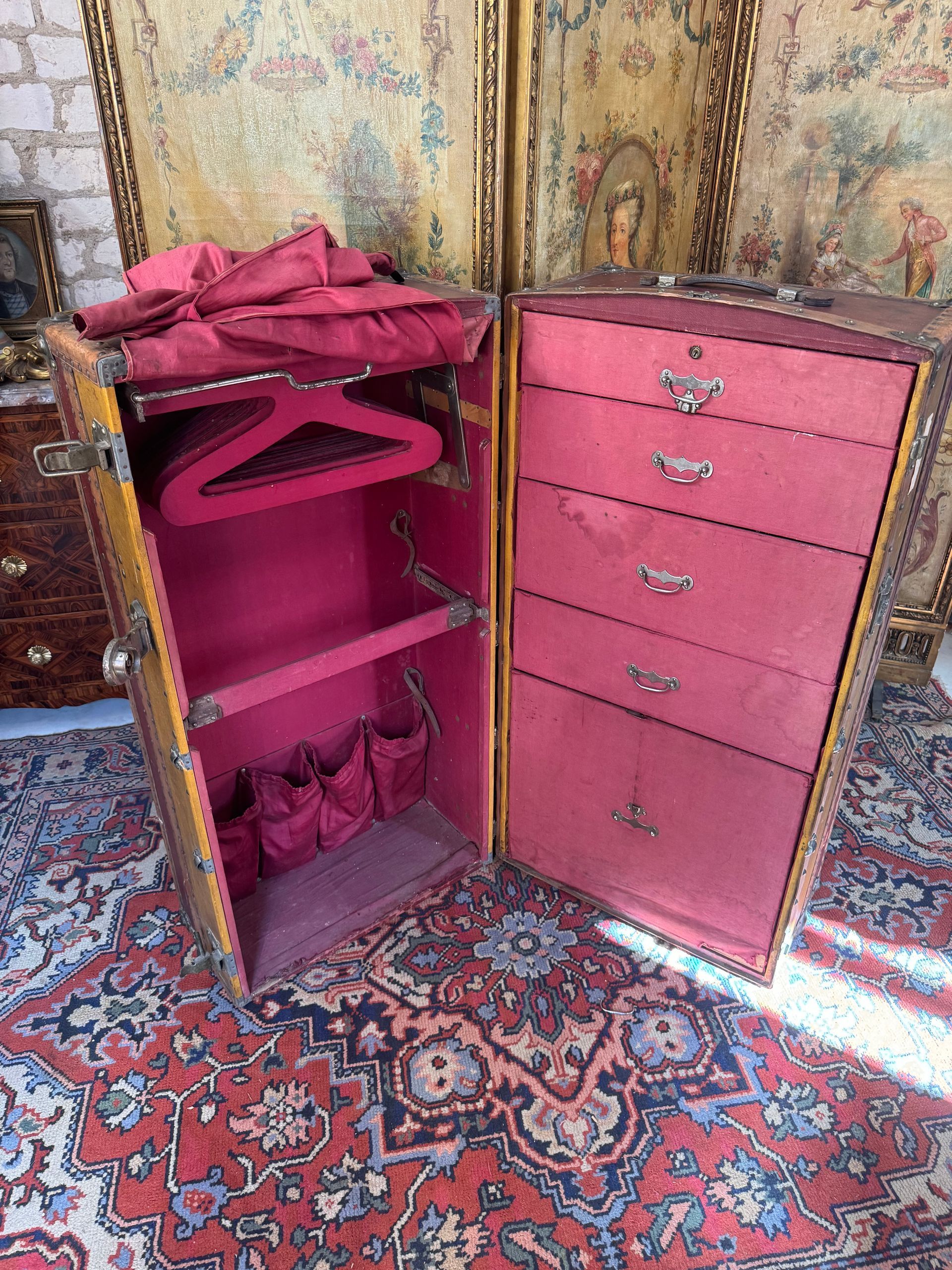 Malle de voyage  ou bateau des années 1920 en bois et cuir avec un décor de losange;
Cette malle,présente un intérieur compartimenté d’un côté de cinq tiroirs et de l’autre côté une penderie avec ses portes manteaux.
Cet intérieur est doté d’un tissu de soie rouge d’origine ( présentant quelques tâches).
Poignée en cuir , serrure et rivets d’origine, 
Ce bagage est dans son état d'origine;