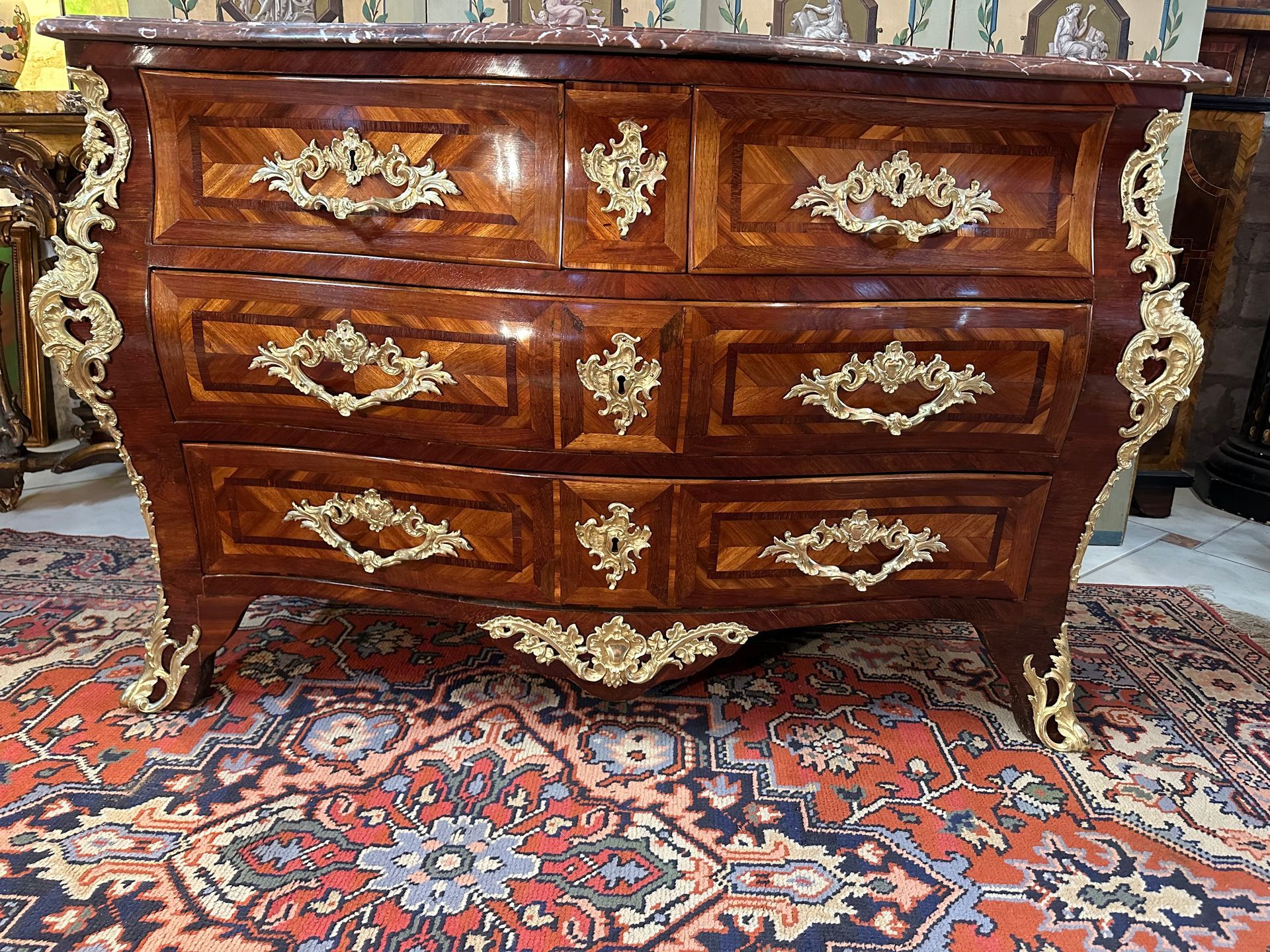 Importante commode dite tombeau époque LOUIS XV – XVIIIème, En bois satiné avec encadrements en amarante , marqueterie à décor géométrique, Façade galbée ouvrant par quatre tiroirs en façade, Très belle ornementation de bronzes dorés et ciselés marqués du C couronné. Coiffée d’un marbre rouge griotte. PORTE L'ESTAMPILLE J.DUBOIS