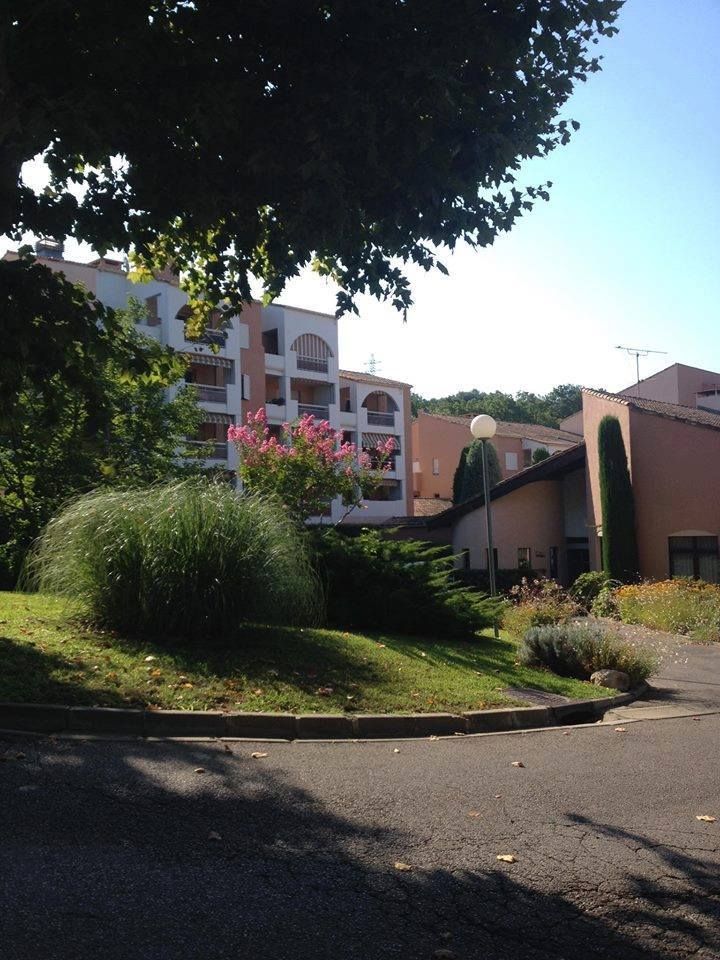 Immeubles d'appartements avec des touches de rose, des arbres et de la verdure.