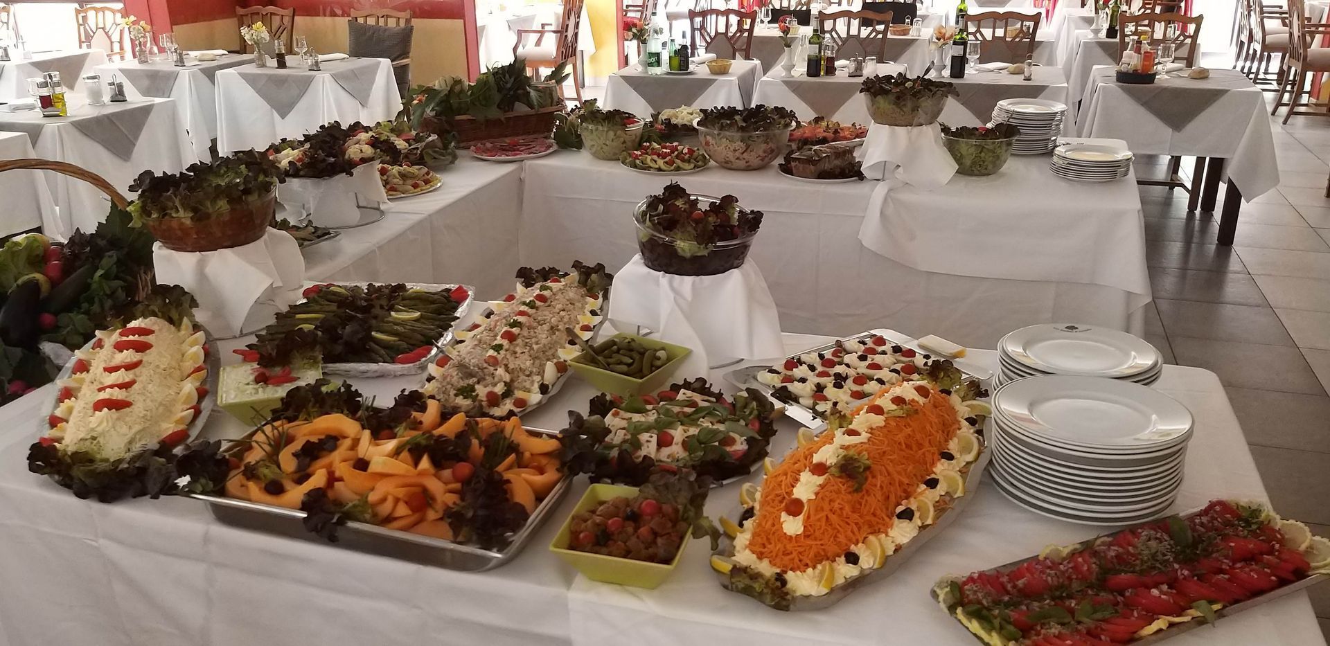 Buffet garni de salades et de plats variés dans un restaurant en plein air.