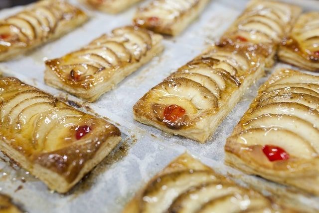 Un montón de pasteles están colocados uno encima del otro sobre una mesa.