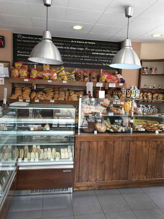 Una panadería con una vitrina llena de pan y patatas fritas.