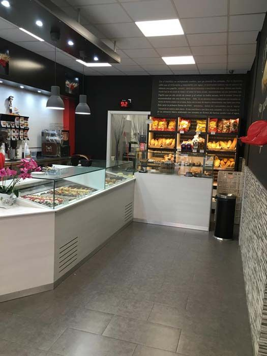 El interior de una panadería con una vitrina de cristal.