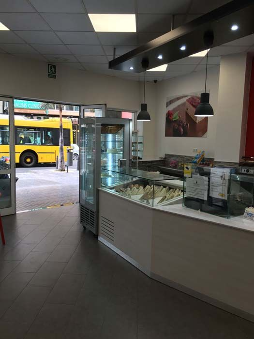 El interior de un restaurante con un autobús amarillo al fondo.