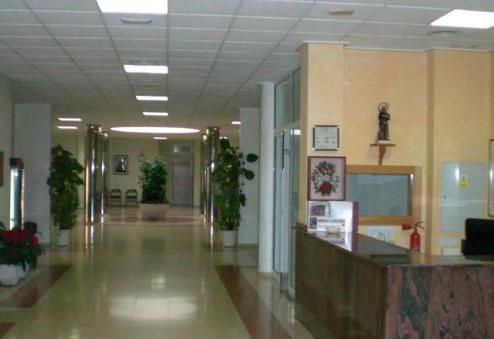 Un largo pasillo en un edificio con un reloj en la pared.