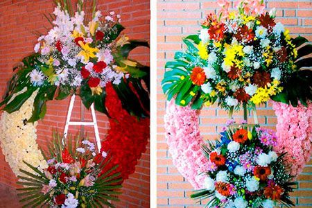 Dos coronas con la letra A están colgadas en una pared de ladrillos.