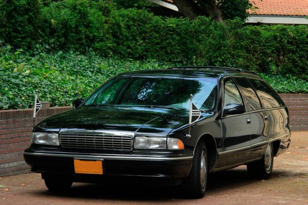 Una camioneta Chevrolet Caprice de color negro está estacionada en una entrada.