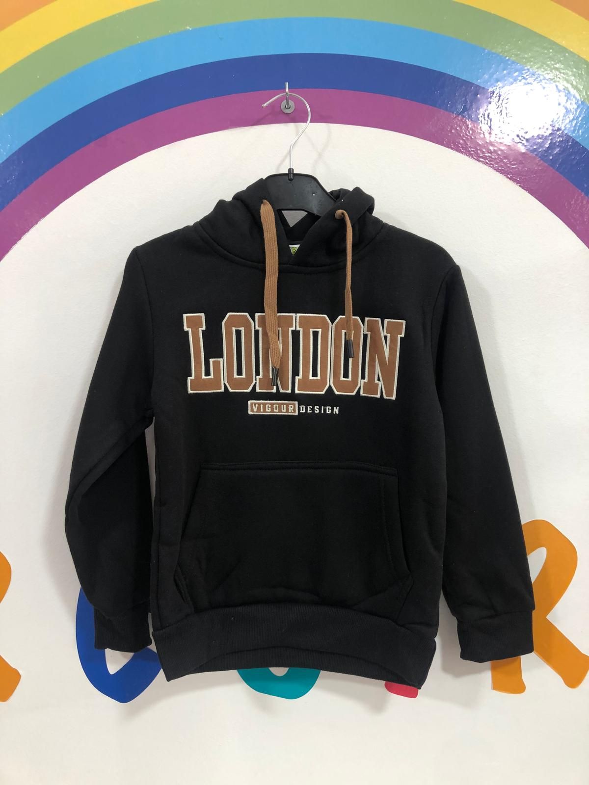 Una sudadera con capucha negra de Londres está colgada en una percha.