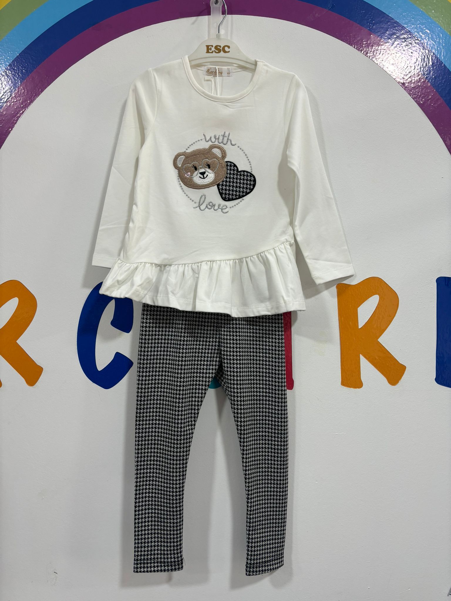 Una camisa blanca con un osito de peluche y un corazón.