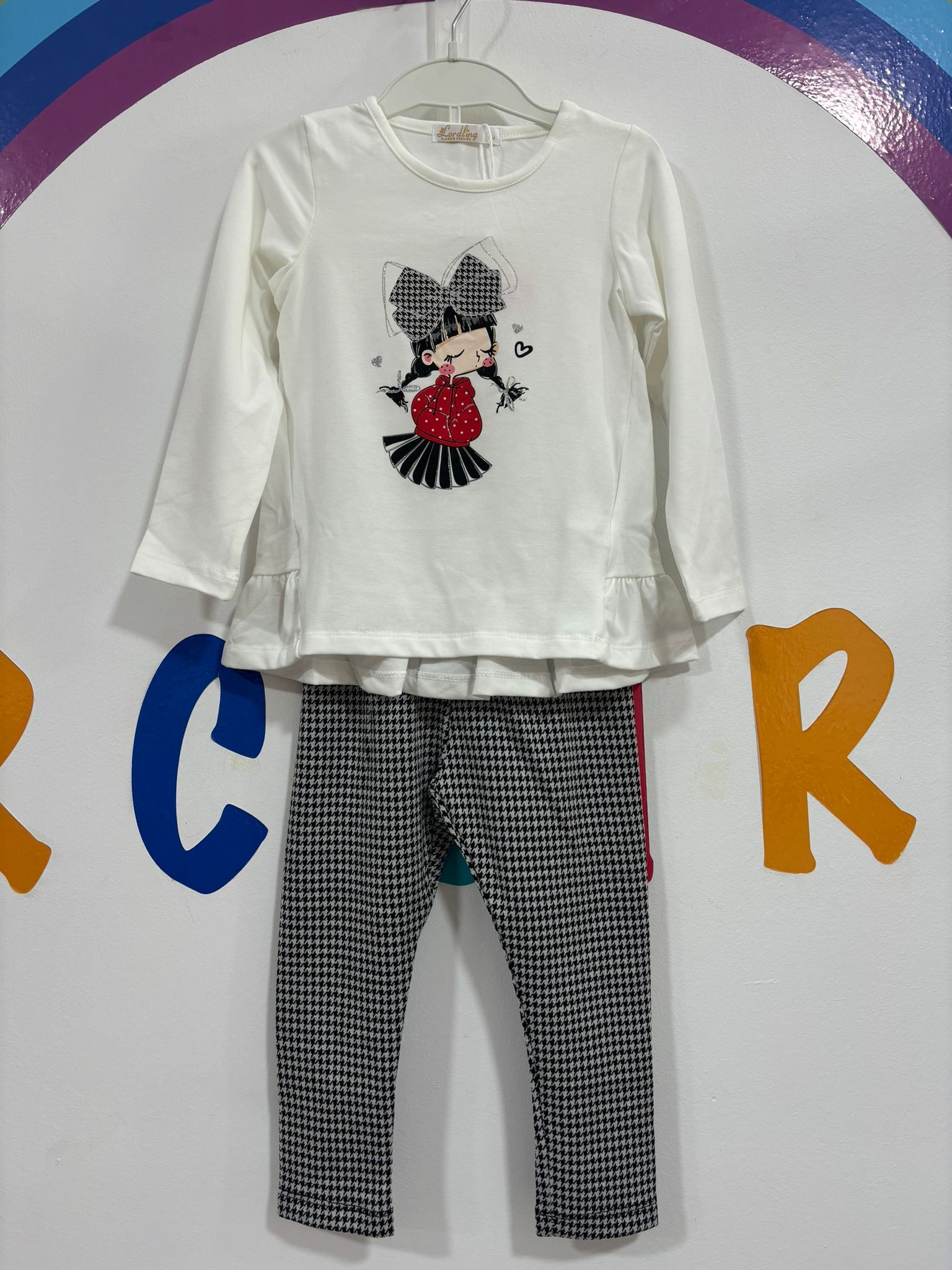 Una camisa blanca con una chica colgada en una percha