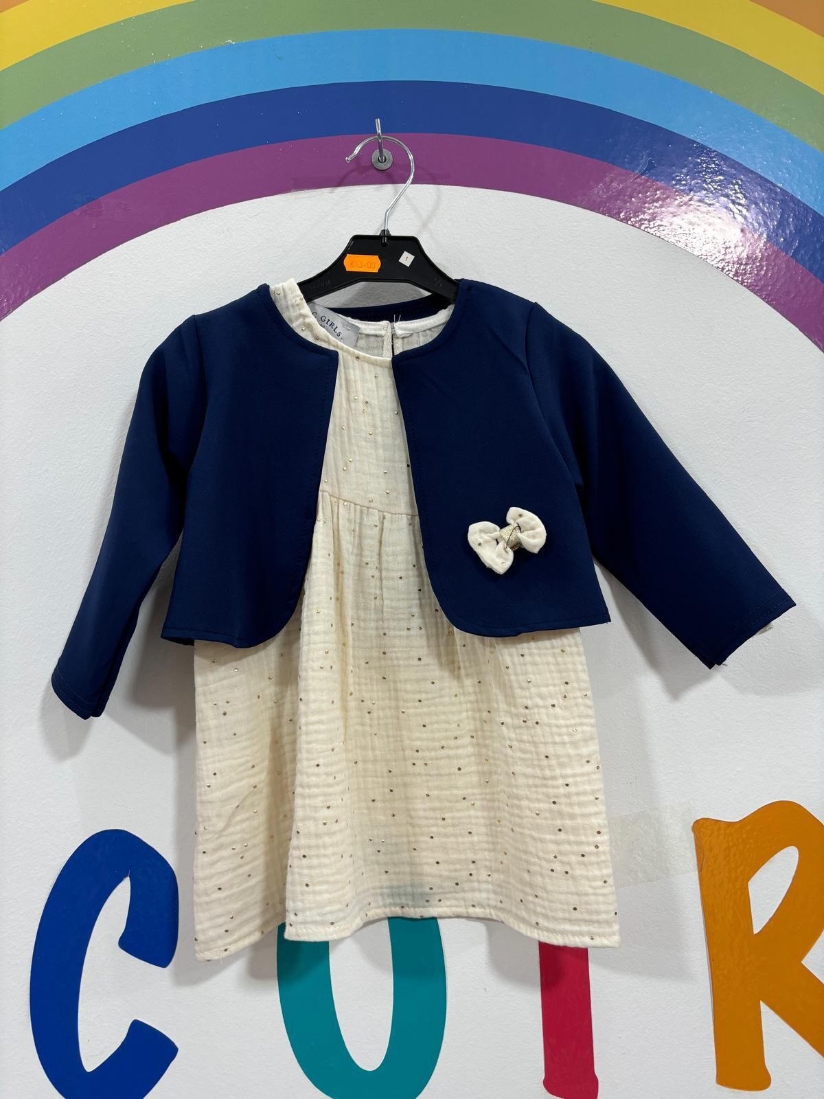 El vestido y la chaqueta de una niña están colgados en una percha.