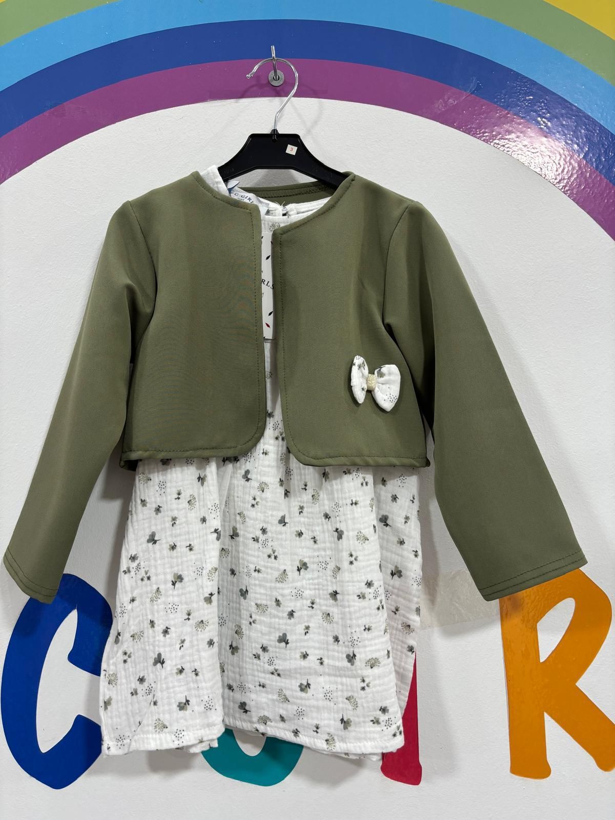 El vestido y la chaqueta de una niña están colgados en una percha.