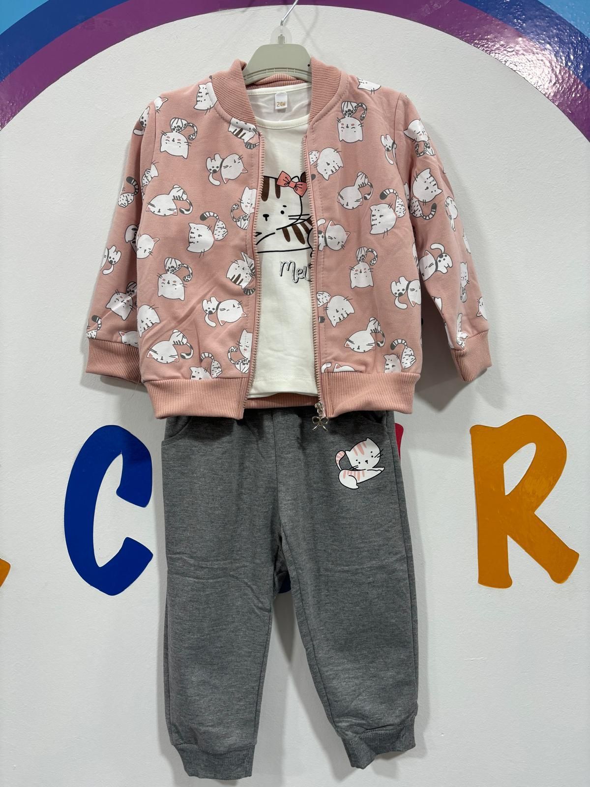 Un traje de niño está colgado en una percha delante de un cartel que dice crr