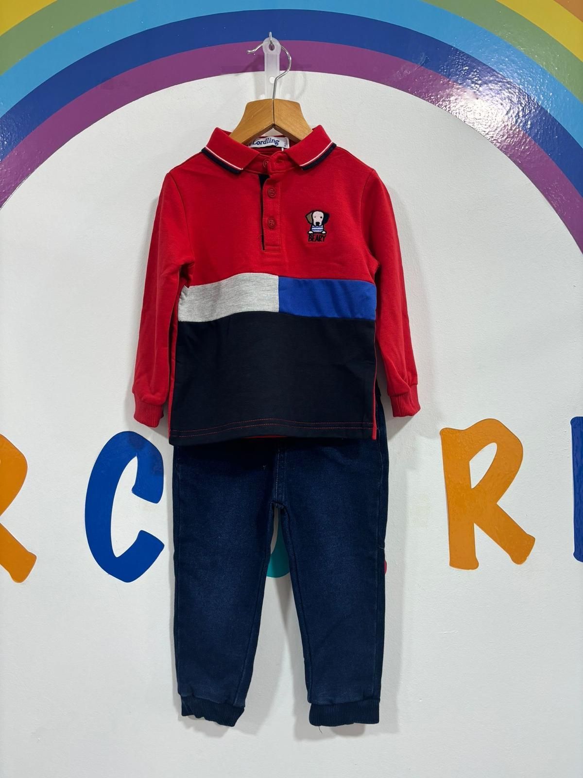 Una camisa roja y unos vaqueros azules están colgados en una percha.