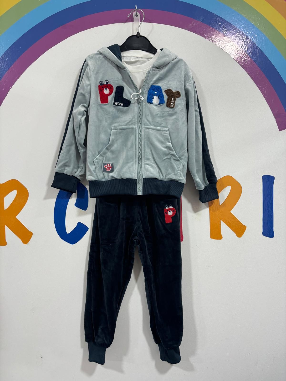 El atuendo de un niño está colgado en una percha frente a un arcoíris.