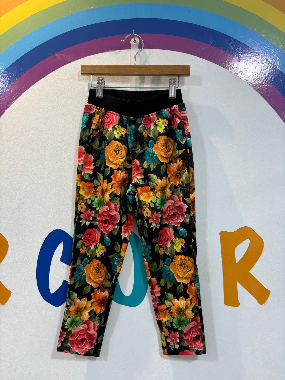 Un par de pantalones floreados colgados en una percha.