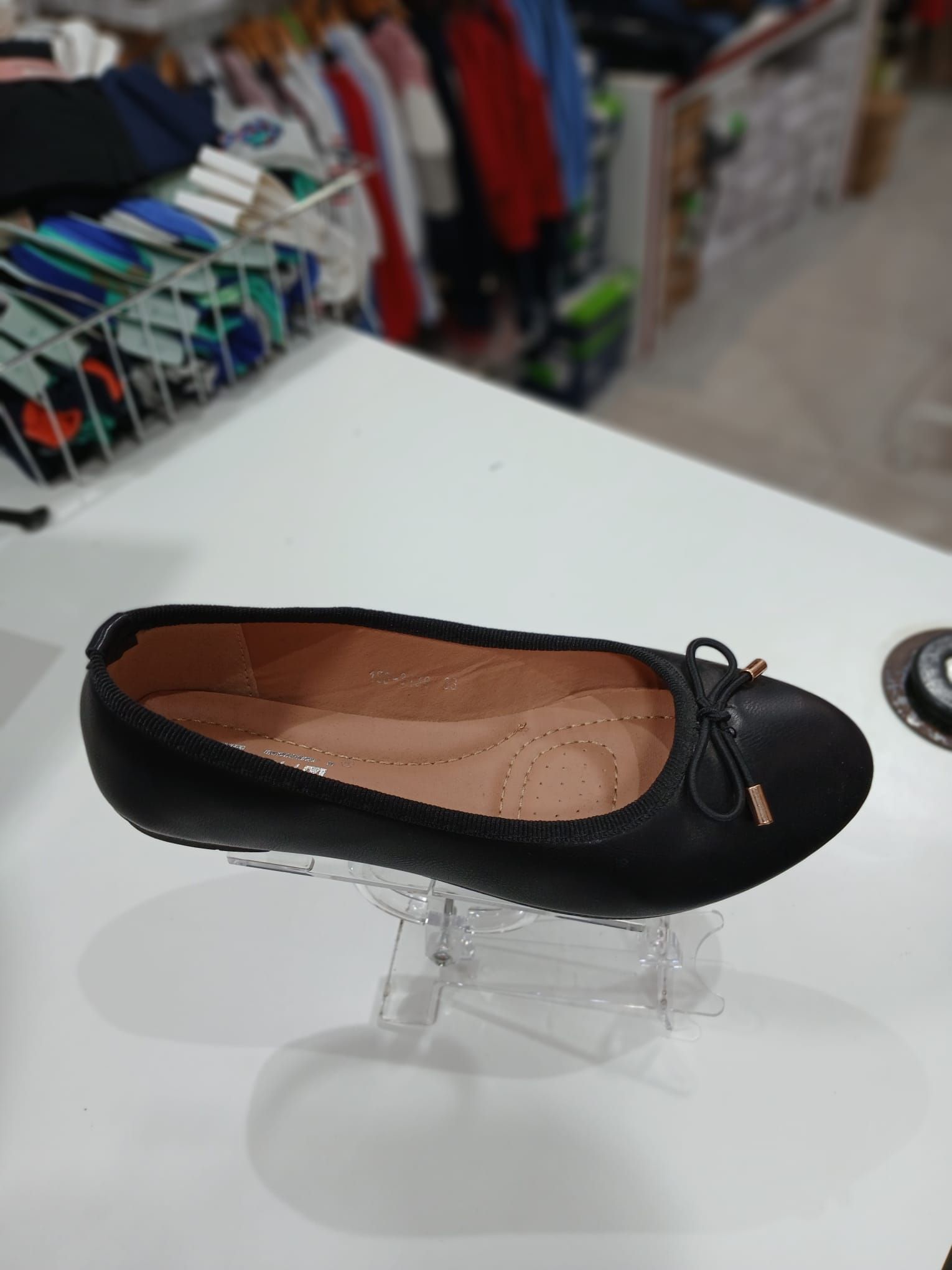 Un par de bailarinas negras sobre una mesa blanca.