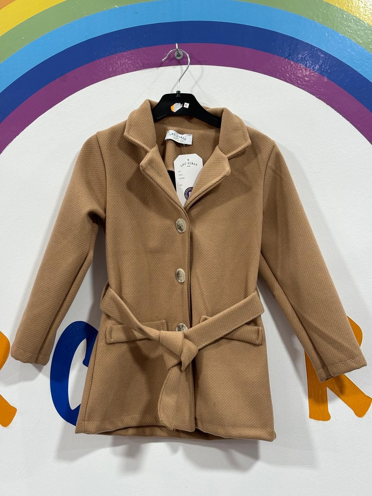 Un abrigo marrón cuelga de una percha delante de un arcoíris.