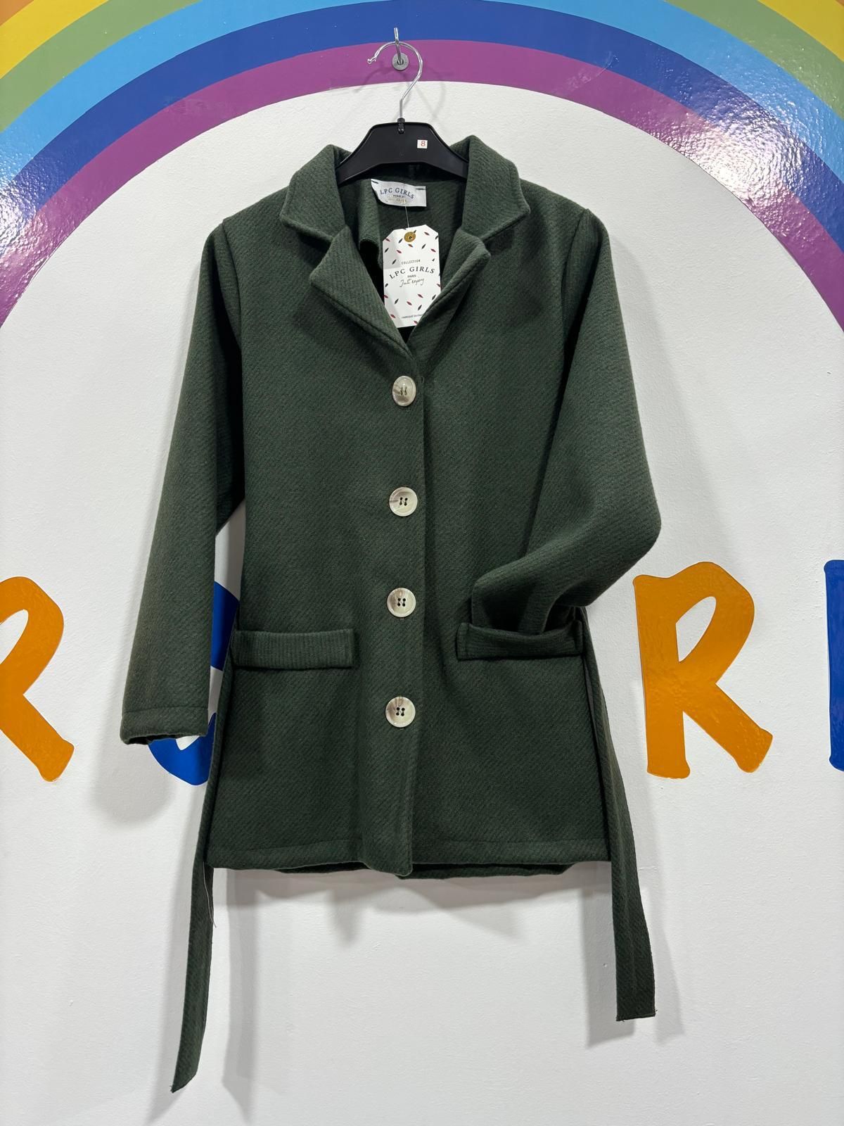 Un abrigo verde cuelga de una percha delante de un arcoíris.