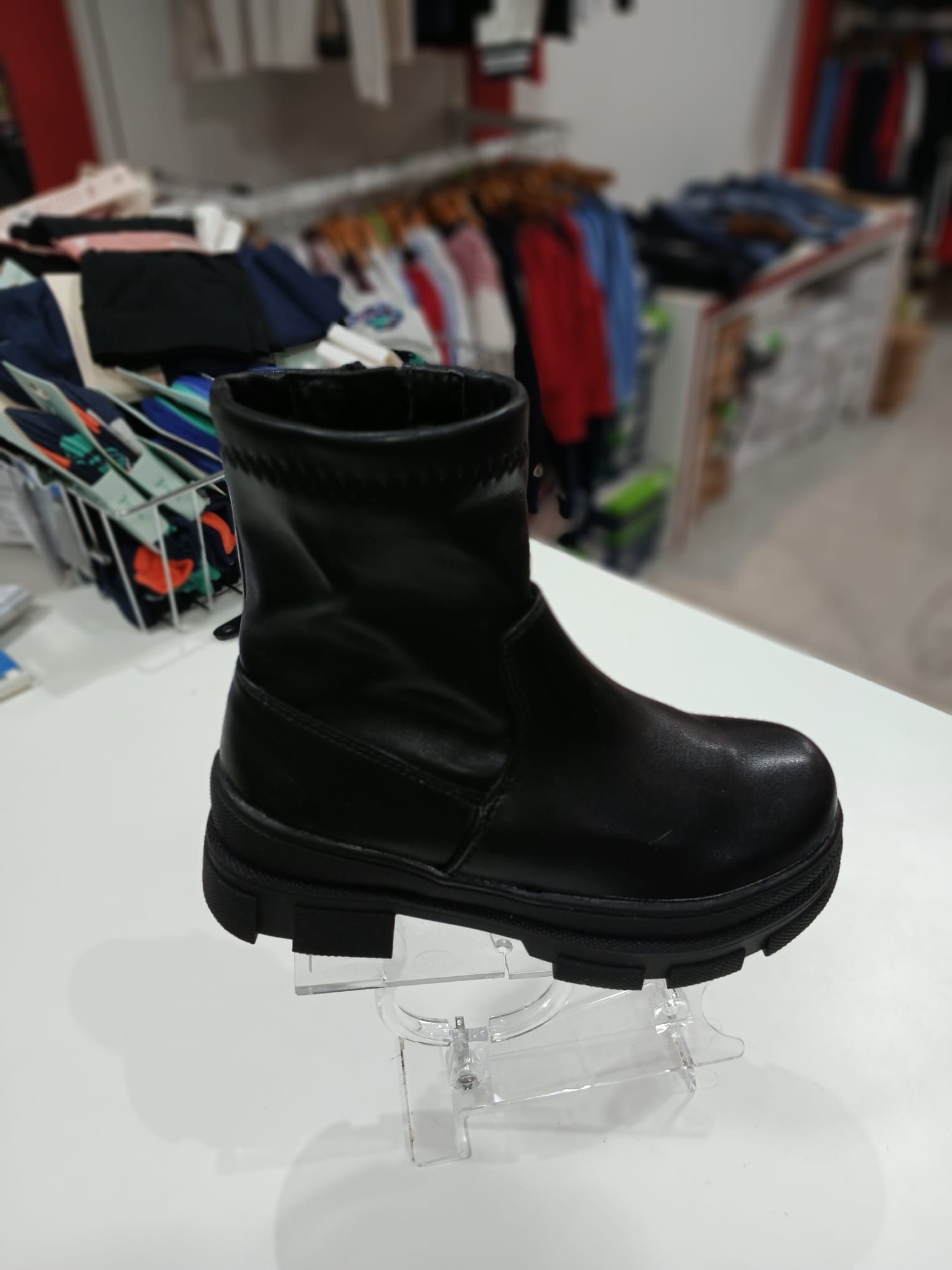 Un par de botas negras sobre una mesa blanca.