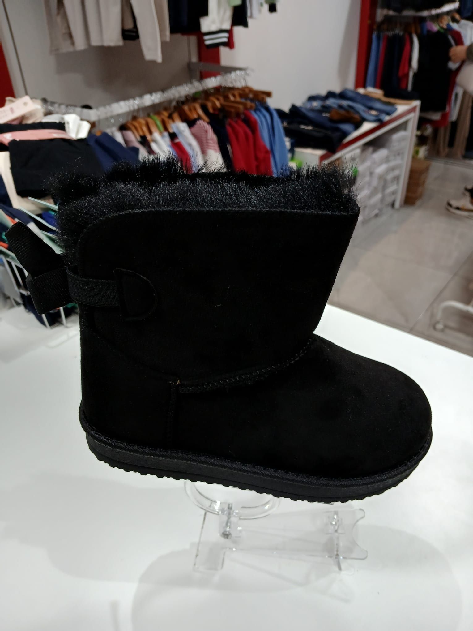 Un par de botas negras están sobre una mesa en una tienda.