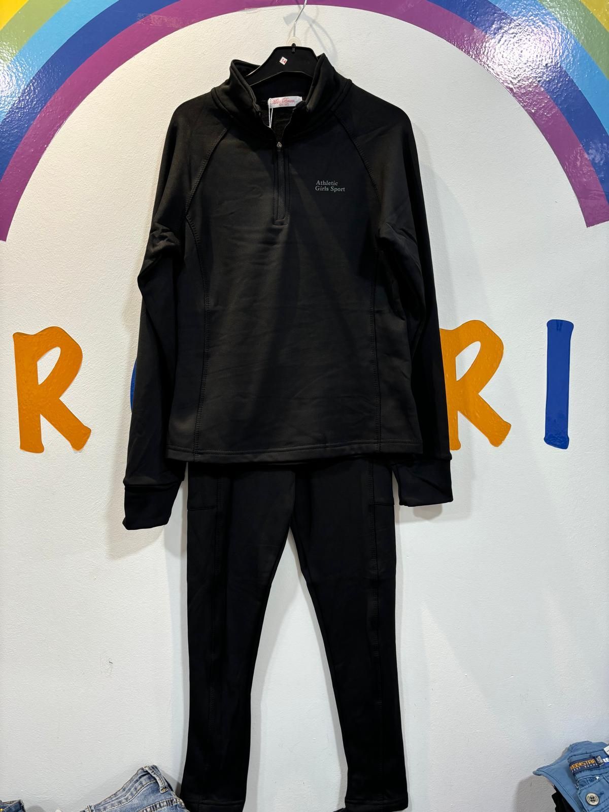 Una chaqueta negra y unos pantalones están colgados en una percha.