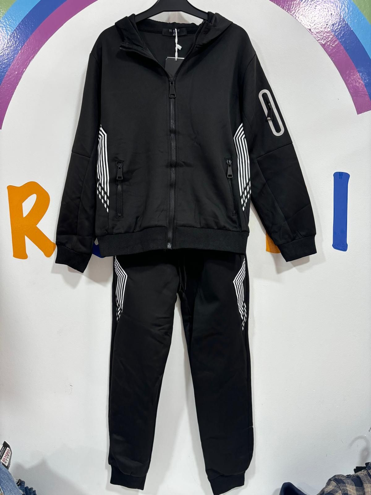 Una chaqueta negra y unos pantalones están colgados en una percha.