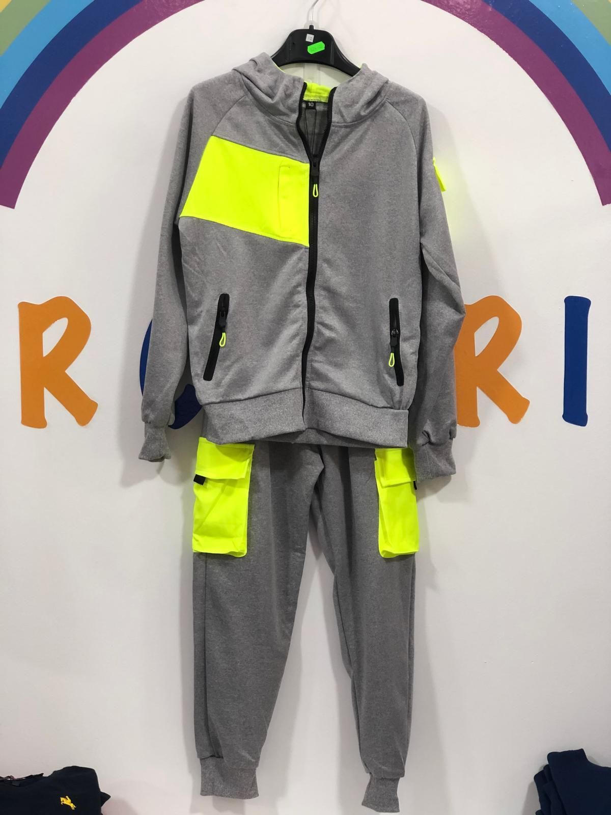 Un chándal gris y amarillo neón está colgado en una percha.