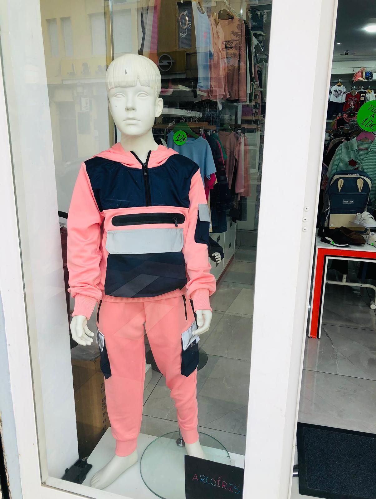 Un maniquí lleva una sudadera con capucha y pantalones de color rosa y negro.