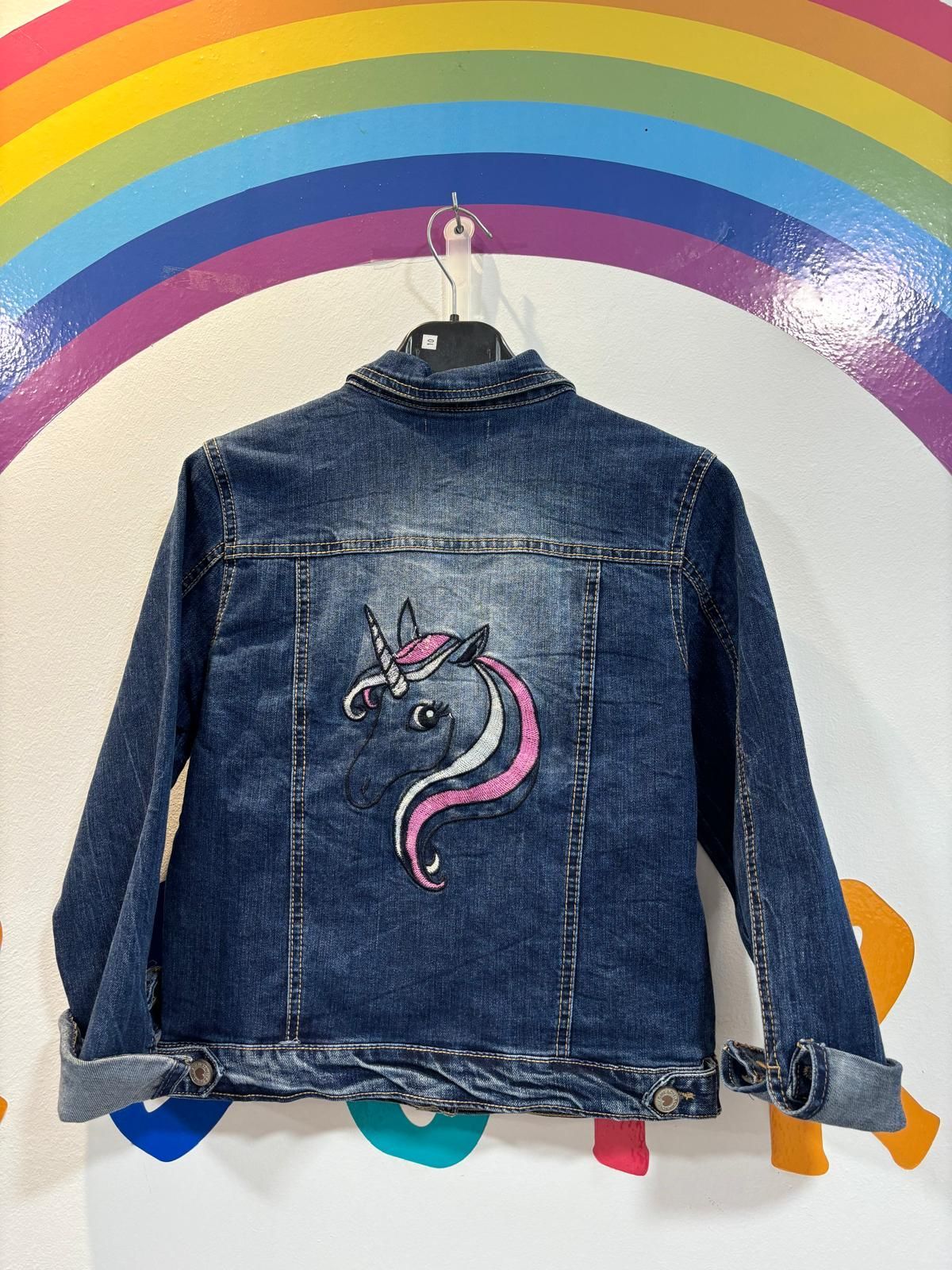 Una chaqueta vaquera con un unicornio pintado en ella.