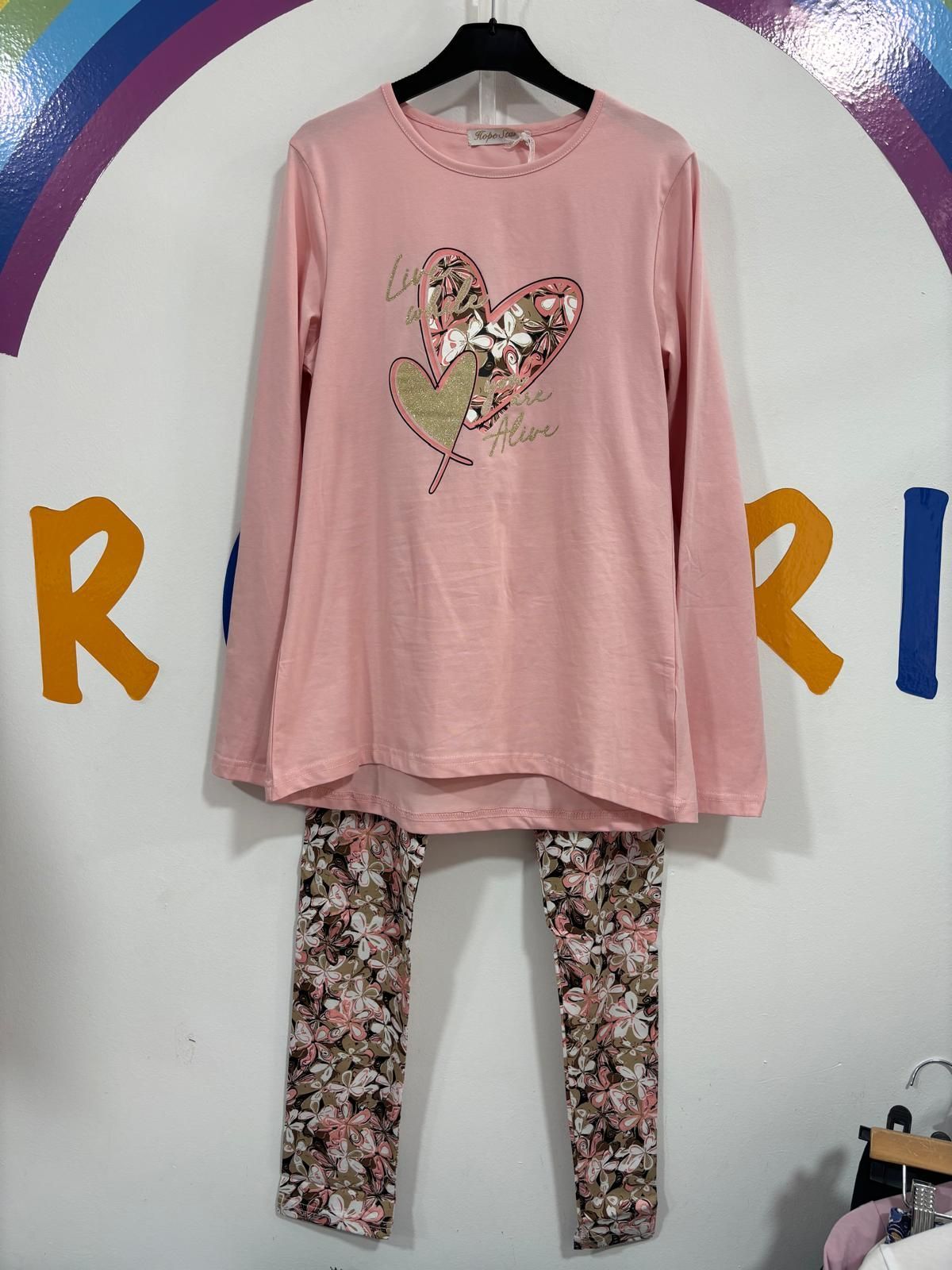 Una camisa rosa con un corazón está colgada en una percha.