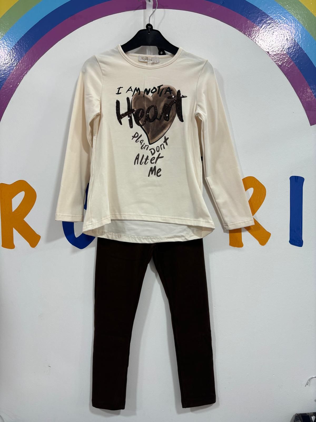 Una camisa blanca con un corazón está colgada en una percha.