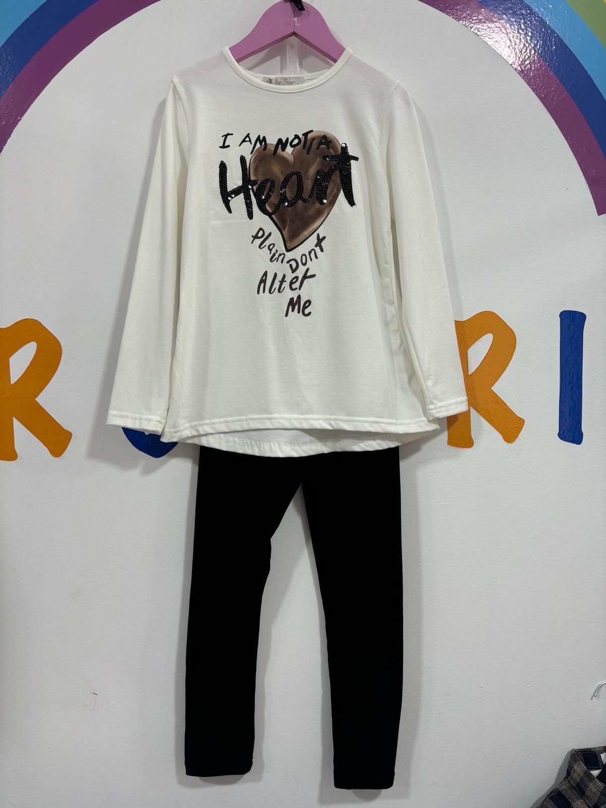 Una camisa blanca con un corazón está colgada en una percha rosa.