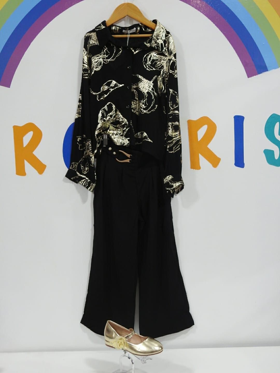 Una camisa negra y un pantalón negro cuelgan de una percha