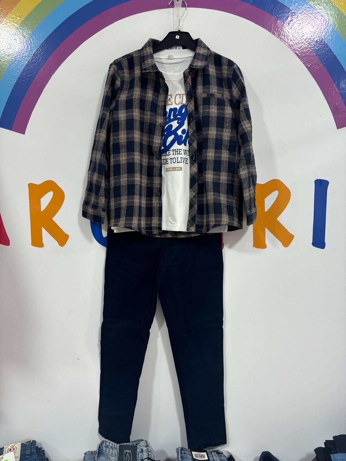 Una camisa a cuadros y unos pantalones están colgados en una percha.