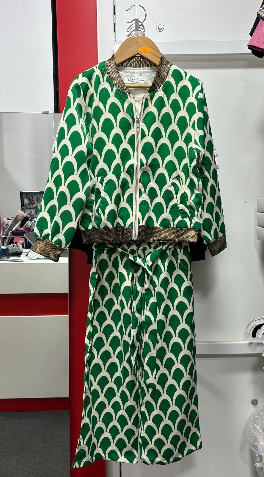 Un vestido verde y blanco está colgado en una percha.