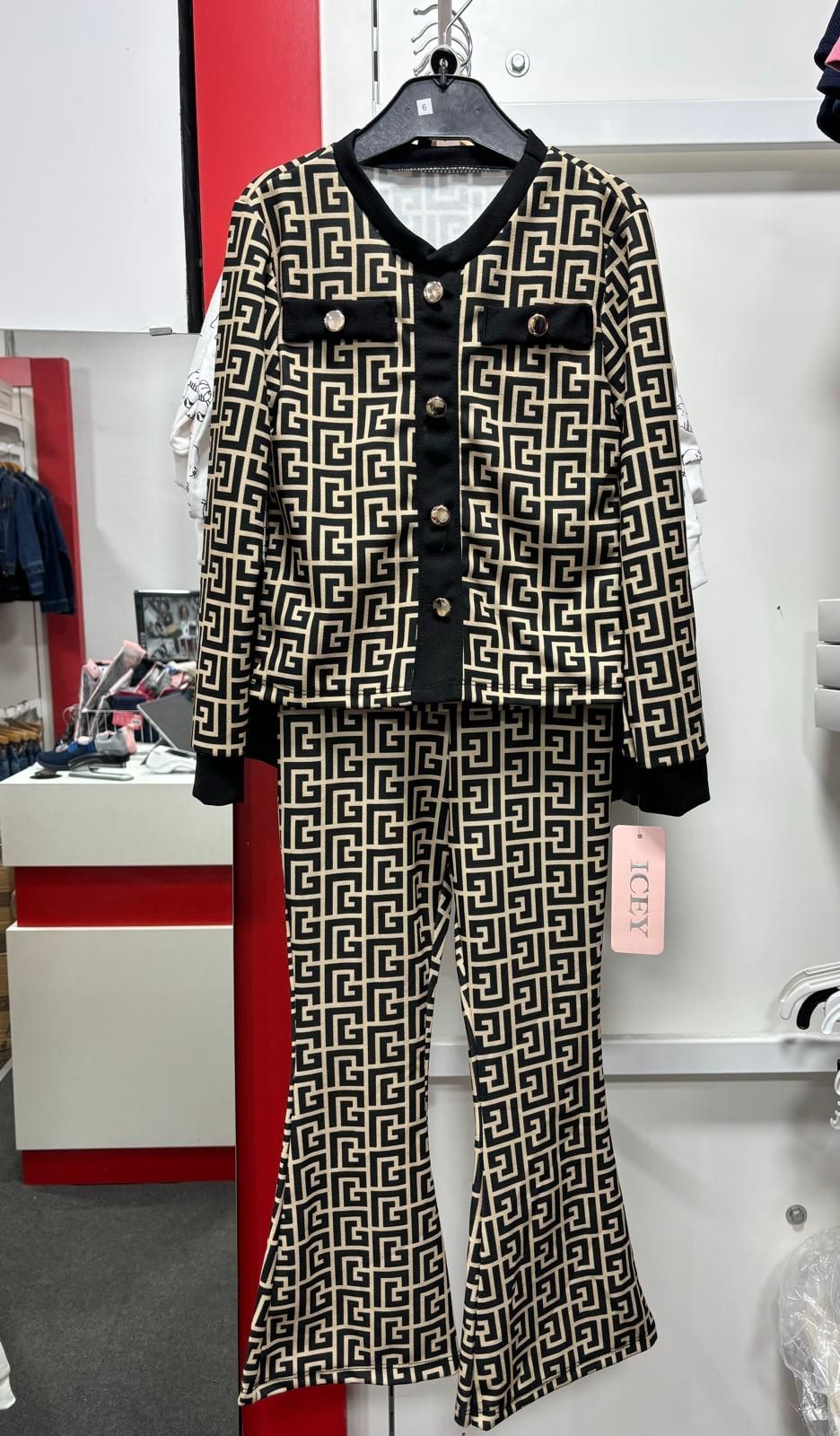 Un conjunto de pijama blanco y negro está colgado en una percha en una tienda.