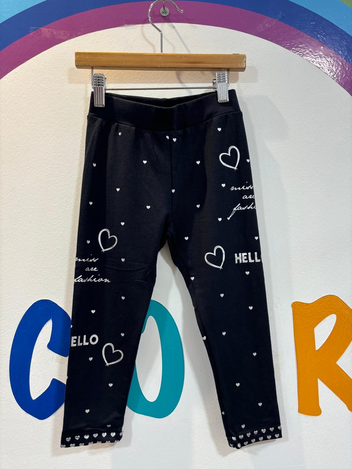 Un par de pantalones negros con corazones y hola escrito en ellos.