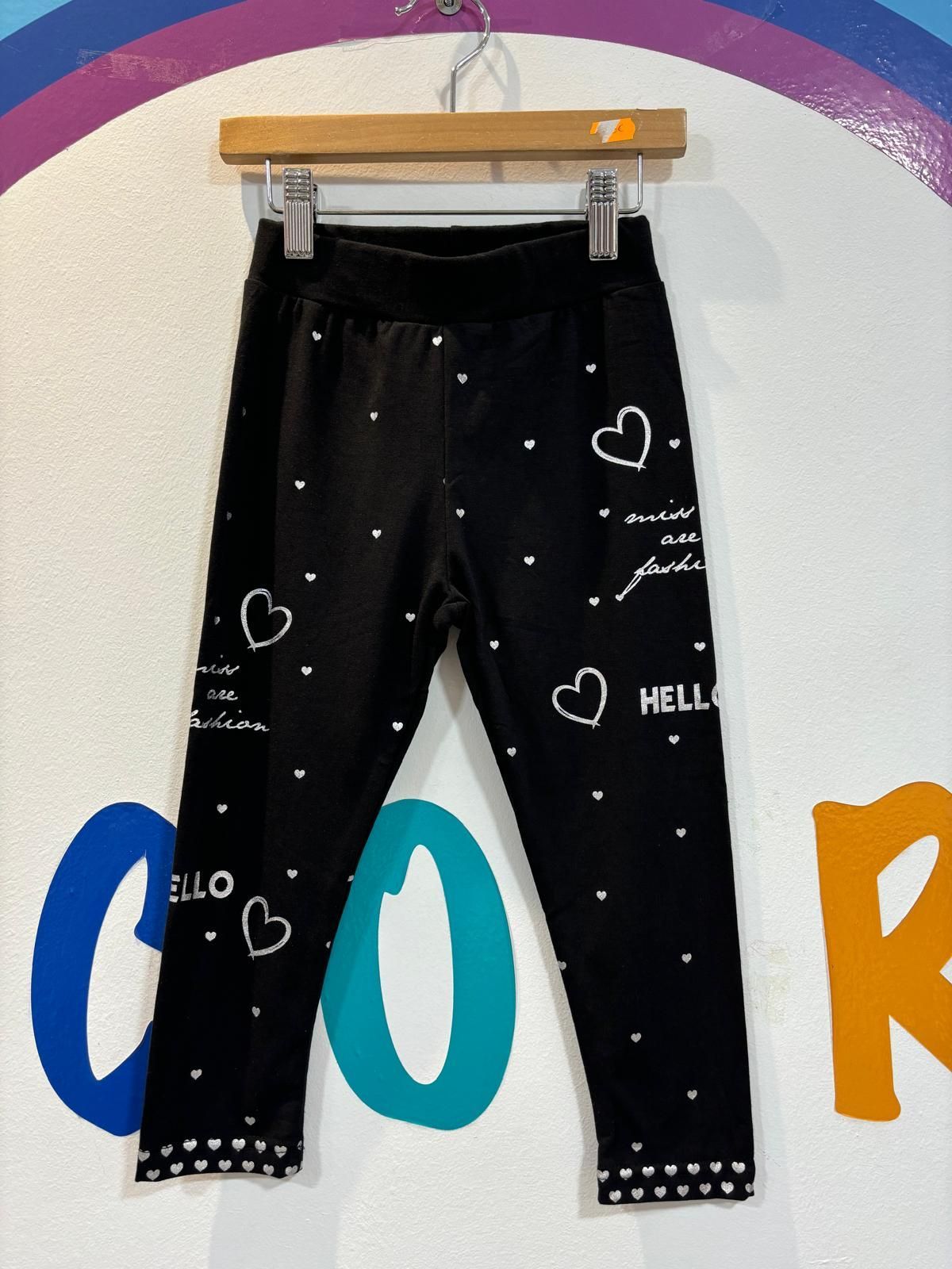 Un par de pantalones negros con corazones y la palabra hola en ellos.