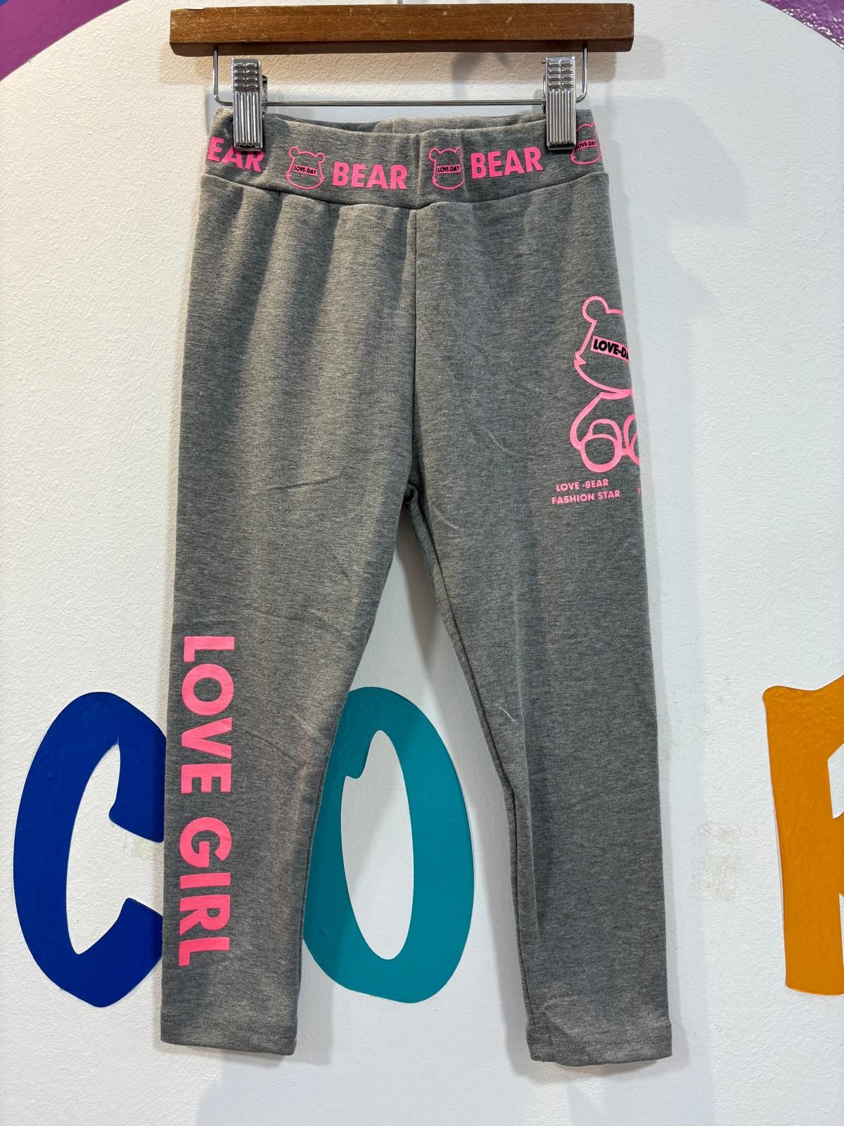 Un par de pantalones grises que dicen Love girl en el costado.