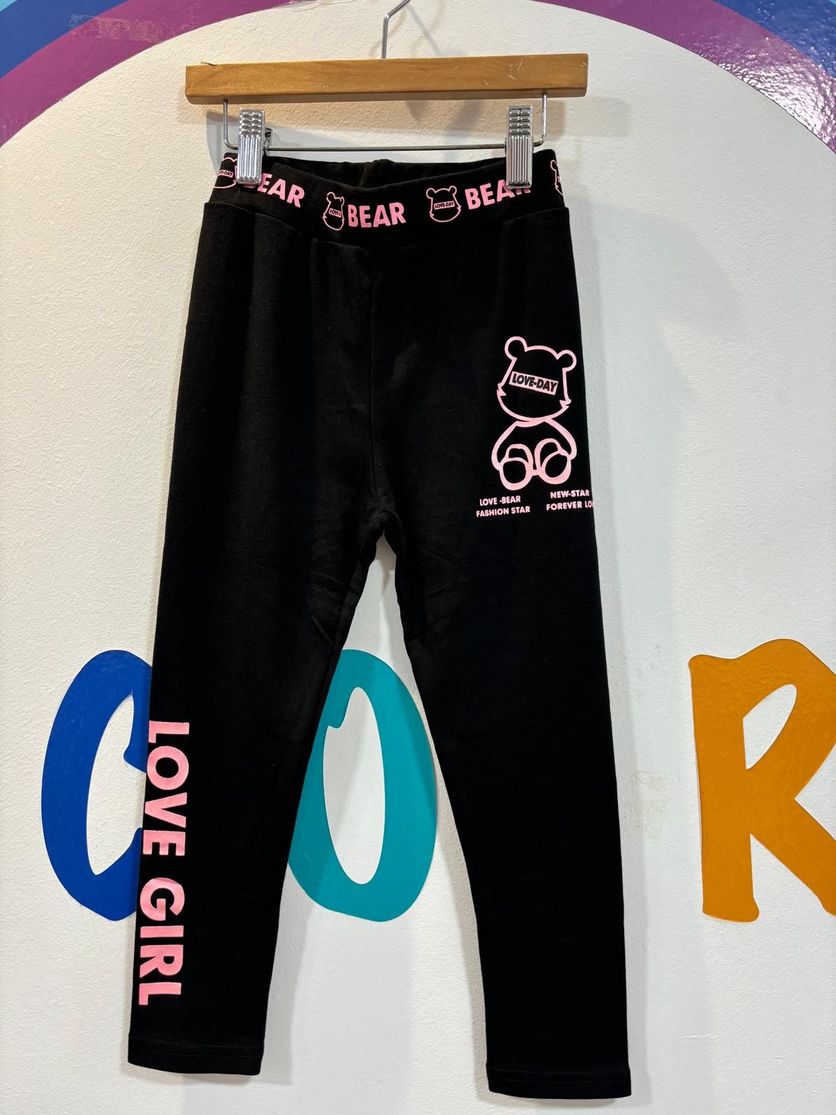 Un par de pantalones negros que dicen Love girl en el costado.