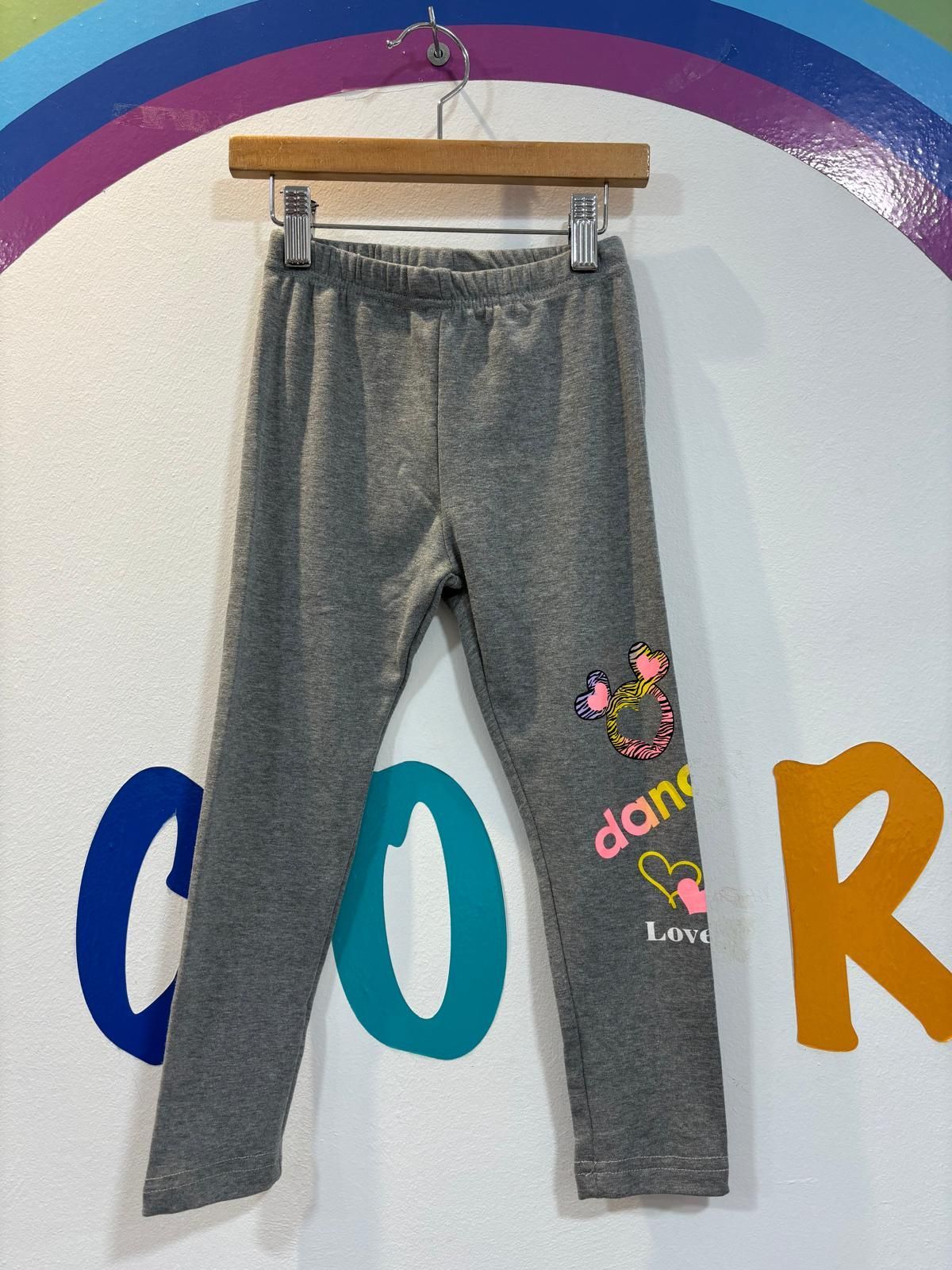 Un par de leggings grises colgados en una percha.