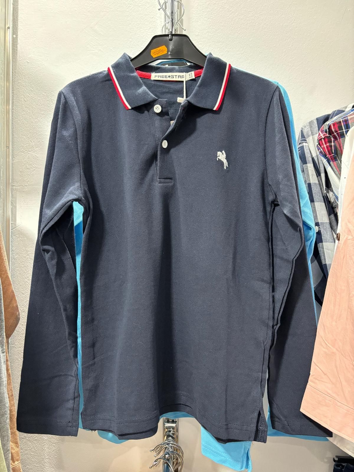 Una camisa polo de manga larga está colgada en un perchero en una tienda.